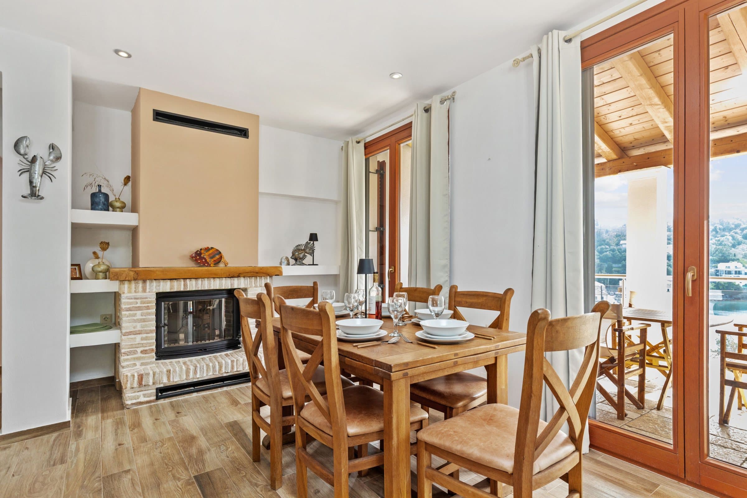 Kitchen and dining area with a wooden table for eight, fireplace and timber-beamed ceiling